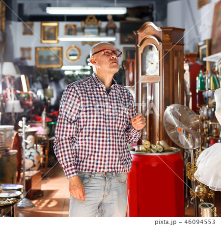 Elderly male carefully examining antiques Elderly male carefully examining antiques 46094553