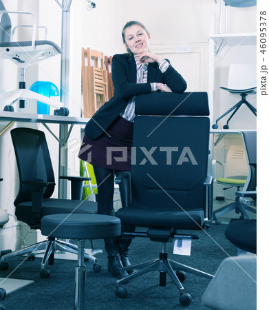 Saleswoman standing in chair store 46095378