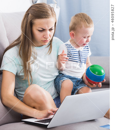 Female is having problems with kid while working 46095827