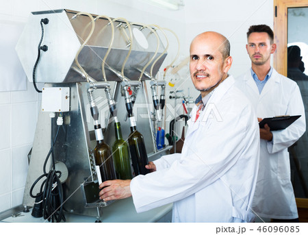 portrait of male winery worker with bottling machinery on factory 46096085