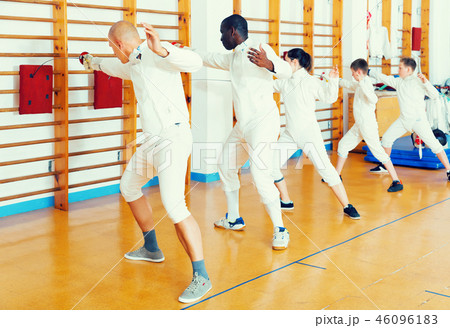 Adult and boys fencers practicing fencing technique Adult and boys fencers practicing fencing technique 46096183