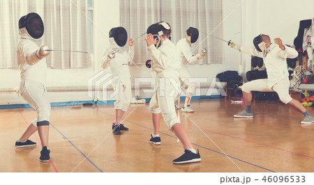 Boys and adults practicing fencing techniques 46096533