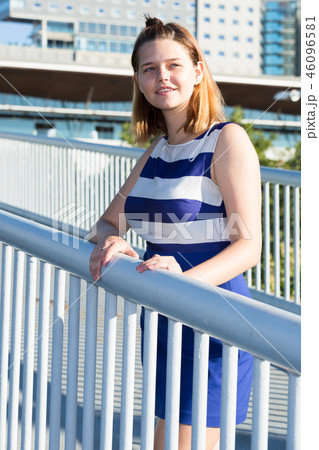 Smiling girl standing on bridge Smiling girl standing on bridge 46096581