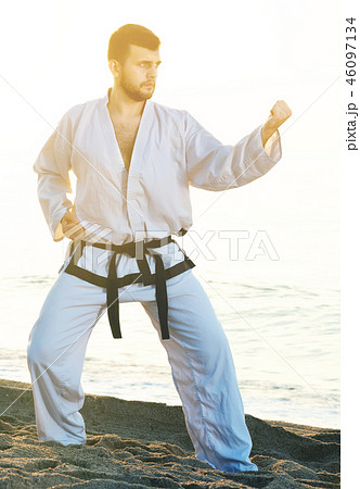 male practising karate poses at seaside male practising karate poses at seaside 46097134
