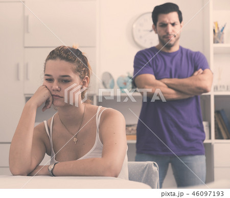 Upset woman at table after discord with husband 46097193