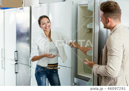 Young assistant in the shop sell a fridge 46097291