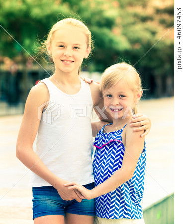 Two small happy sisters outdoors Two small happy sisters outdoors 46097453