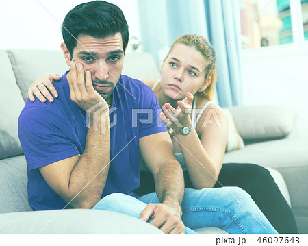 Ggirl comforting upset boyfriend on sofa Ggirl comforting upset boyfriend on sofa 46097643