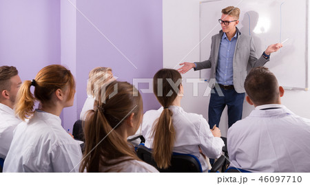 Positive male teacher lecturing to students Positive male teacher lecturing to students 46097710
