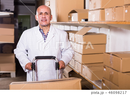 Portrait of mature man standing with cart Portrait of mature man standing with cart 46098217