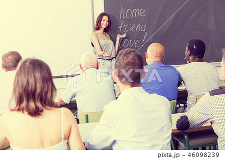 Serious female lecturer talking to students 46098239