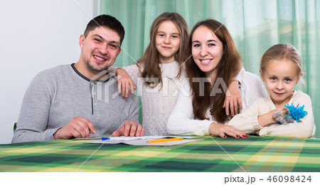 parents with little children buying insurance and smiling 46098424