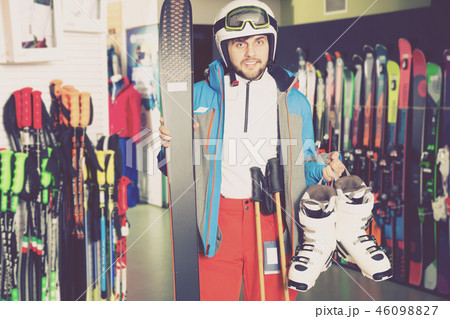 Smiling man posing in skiing gear in sport equipment shop 46098827
