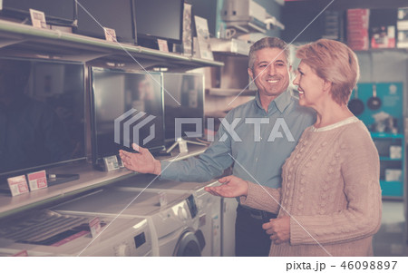 Mature couple buy in shop of household appliances TV 46098897