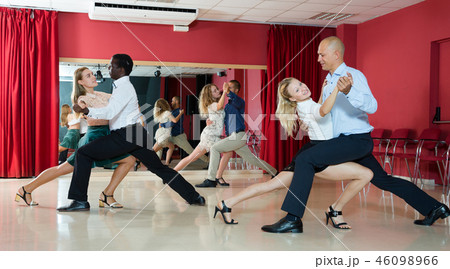 Adult pairs dancing tango movements in modern dance studio 46098966