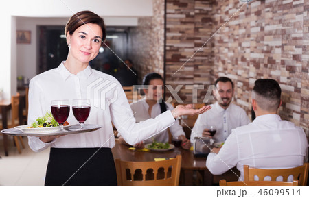 Smiling woman waitress carrying order for guest Smiling woman waitress carrying order for guest 46099514