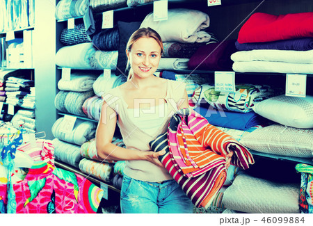 Youngwoman buying bed spread in textile store 46099884