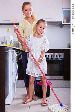 Mother and daughter cleanup at kitchen. Mother and daughter cleanup at kitchen. 46100143