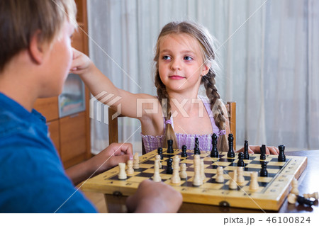 children at chess board indoors 46100824