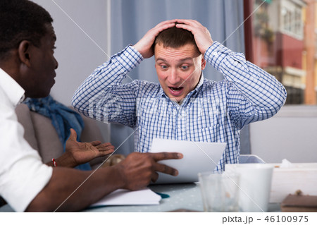 Man worriedly discussing with friend at home Man worriedly discussing with friend at home 46100975
