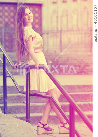 young woman walking in historic city center 46101107