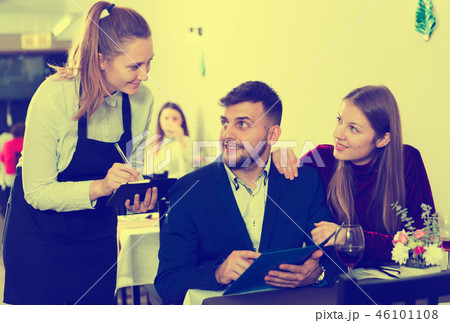 Couple is giving order to female waiter in luxury restaurante Couple is giving order to female waiter in luxury restaurante 46101108