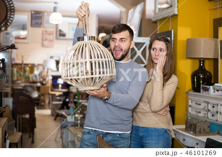 Raptured guy and surprised girl wth hanging lamp 46101269