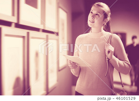 Modern girl holding guide book in museum 46101529