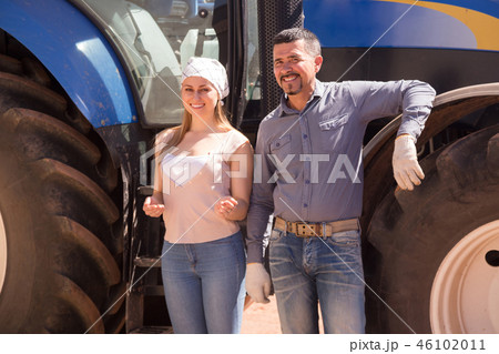 Two farmers close to huge tractor. Two farmers close to huge tractor. 46102011