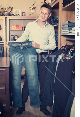 Brunette guy deciding on new trousers Brunette guy deciding on new trousers 46102017