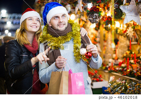 Couple in hat at Christmas Fair, girl points to decorations 46102018