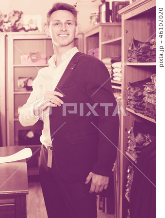 Smiling male choosing new suit in male store Smiling male choosing new suit in male store 46102020