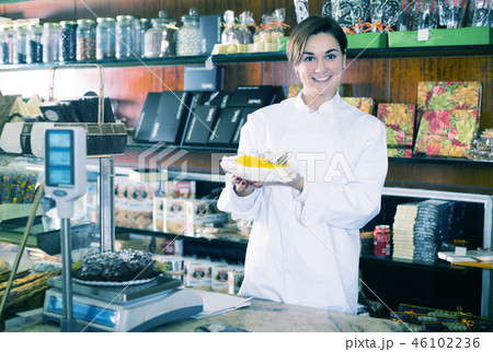 Shop assistant demonstrating delicious pie Shop assistant demonstrating delicious pie 46102236