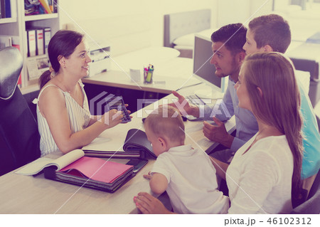 Saleswoman calculating cost of order for family Saleswoman calculating cost of order for family 46102312