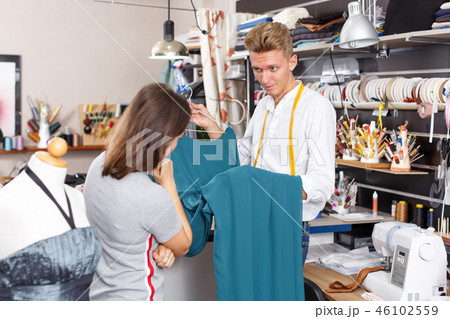 Tailor showing customer dress Tailor showing customer dress 46102559