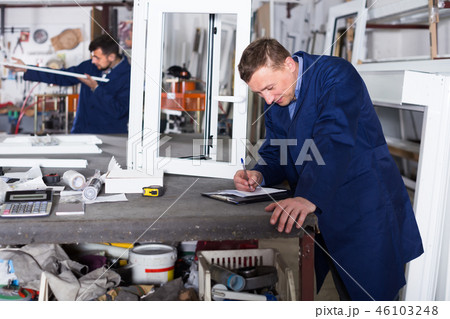 thoughtful male surveyor in coverall working with documents at workshop 46103248