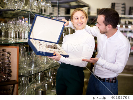 Couple examining cutlery sets in dinnerware store 46103708