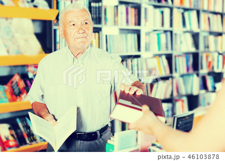 Mature male is buying book Mature male is buying book 46103878