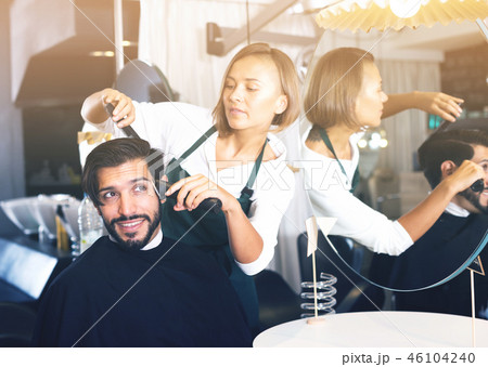female professional shaving male's hair 46104240