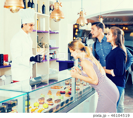 Man is offering delicious cakes from showcase 46104519