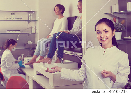 Young nail salon master inviting clients to procedure 46105215