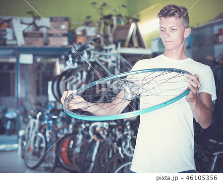 Portrait of customen man who is holding bicycle wheel Portrait of customen man who is holding bicycle wheel 46105356