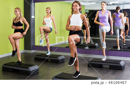 Women doing step aerobics exercises Women doing step aerobics exercises 46106467