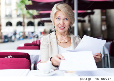 Portrait of elegant mature female who is reading documents in time lunch with coffee 46106537