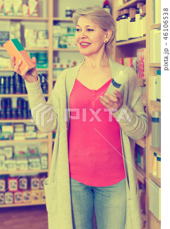 Pretty female client browsing rows of skin care products 46106538