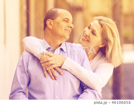 elderly woman hugging man while walking 46106858