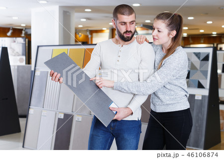 Young family couple standing with sample of ceramic tile Young family couple standing with sample of ceramic tile 46106874