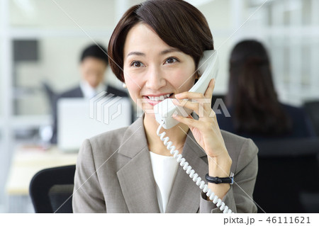 会社で電話をかける女性の写真素材