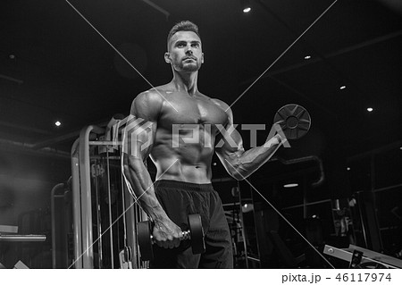 Handsome man with big muscles, posing at the camera in the gym 46117974