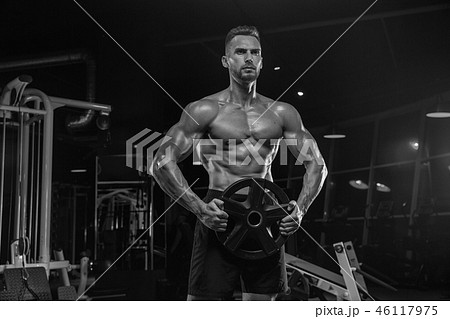 Handsome man with big muscles, posing at the camera in the gym 46117975
